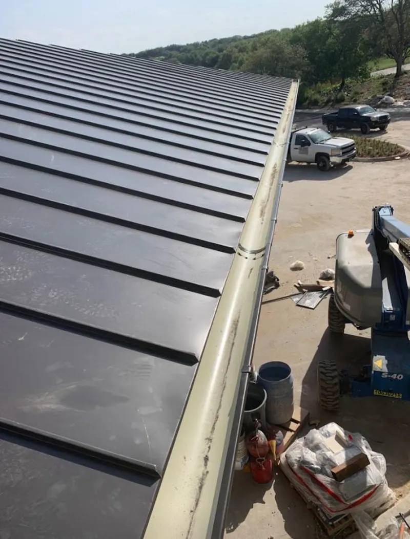 Standing seam panel and gutter detail on a metal roofing jobsite in Tanaina